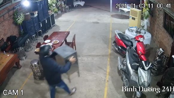 Lợi dụng không có người, một đối tượng lẻn vào bê thùng tiền phúng điếu (Ảnh: Bình Dương 24h)