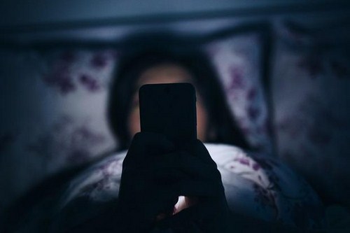 Dùng điện thoại trong bóng tối gây mù