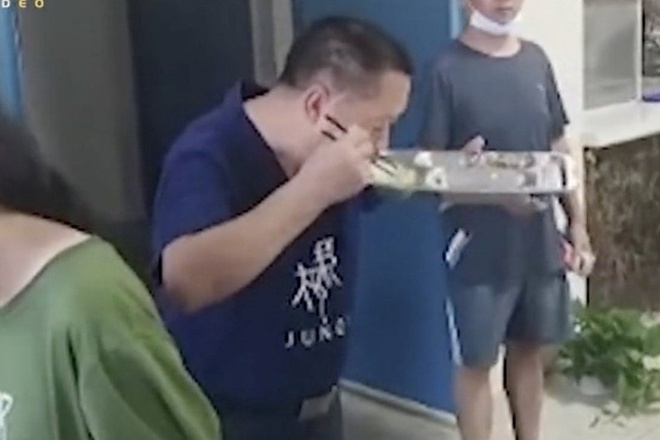 Thầy Wang ăn phần thức ăn thừa của học sinh.