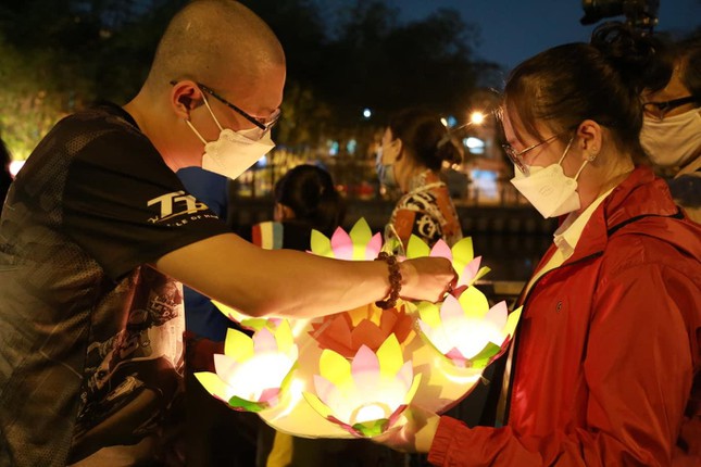 Người dân tại chùa Pháp Hoa thắp sáng những đóa hoa để tưởng niệm, cầu siêu cho những người không may ra đi vì đại dịch. (Ảnh: Tiền Phong)
