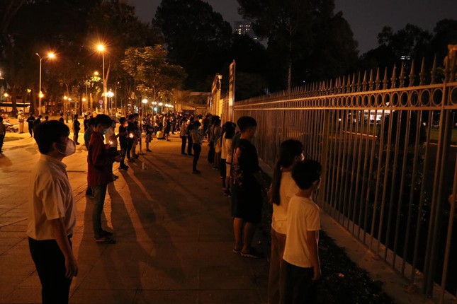 Rất nhiều người đứng bên ngoài hàng rào Hội trường Thống Nhất thắp nến tưởng niệm, tiễn biệt những người mất vì đại dịch. (Ảnh: Tiền Phong)