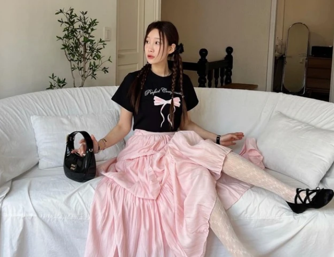 Hồng phối đen đầy dễ thương. Ulzzang Hyemin kết hợp áo phông thêu nơ với chân váy hồng pastel và kiểu tóc tết tinh nghịch. Các món phụ kiện hot trend như quần tất ren lưới, giày búp bê ballet và túi xách 