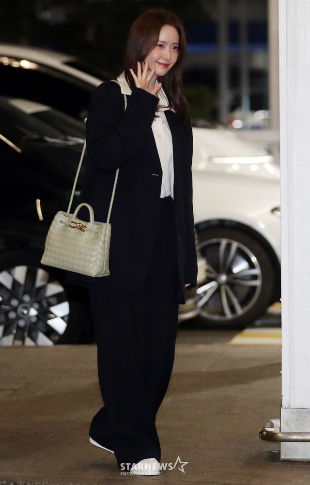 Yoona diện một set đồ rất đơn giản gồm áo sơ mi trắng, bộ suit màu đen và giày sneaker màu trung tính. Dẫu vậy, bộ trang phục vẫn ấn tượng vừa cool ngầu vừa phong cách.