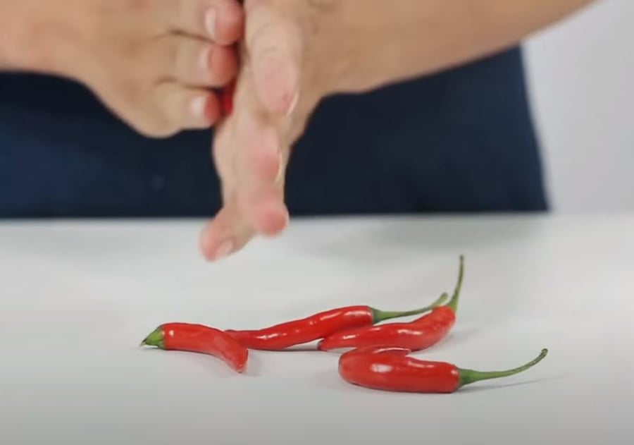 Dùng tay lăn quả ớt qua lại cho phần hạt ớt bong ra khỏi lõi.