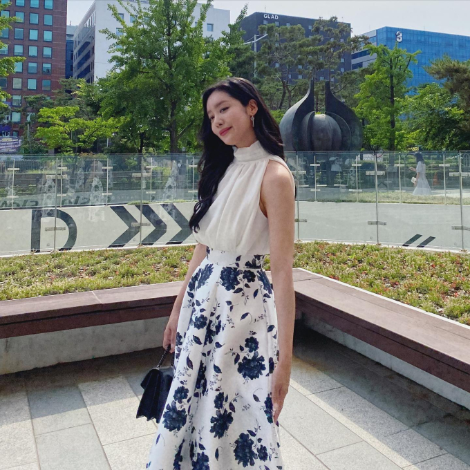 Cha Joo Young ưu tiên áo thiết kế cổ cao rồi kết hợp với chân váy hoa thanh lịch, nữ tính. Sơ vin là thao tác không thể thiếu để nâng tầm bộ trang phục.

