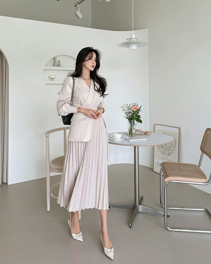 Chị em nên kết hợp chân váy xếp ly với áo sơ mi nhấn eo, áo blouse tay bồng để tạo nên những bộ cánh công sở nổi bật và thanh lịch.