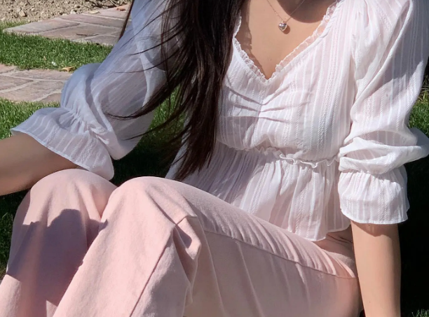 Sự kết hợp giữa áo blouse trắng và quần màu hồng pastel giúp vẻ ngoài thêm trẻ trung, ngọt ngào. Cô nàng này còn dùng dây buộc tóc scrunchie như một chiếc vòng đeo tay.    
