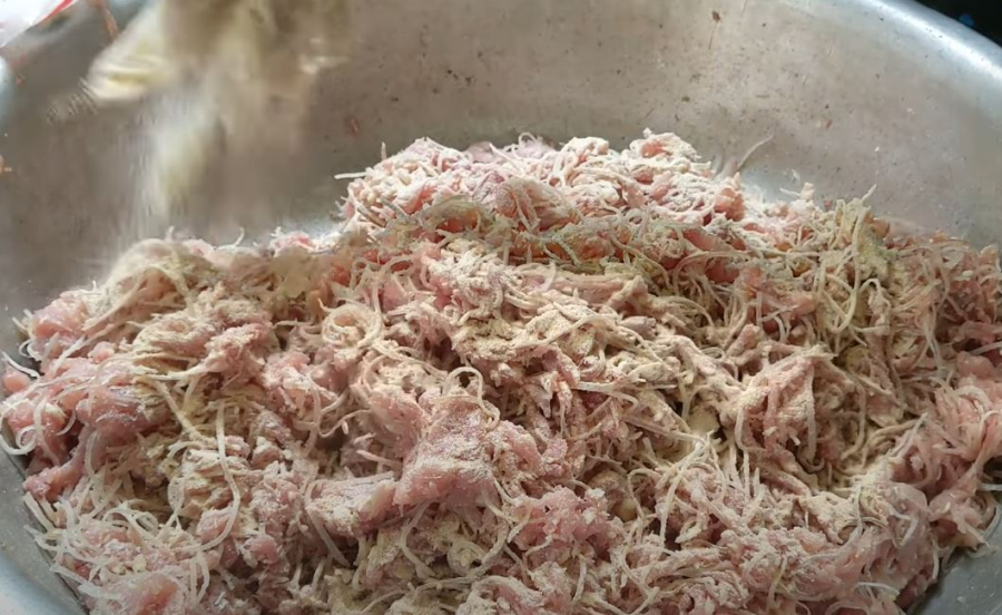 Thịt lợn sẽ được trộn với thính gạo và các loại gia vị khác trước khi đem gói.