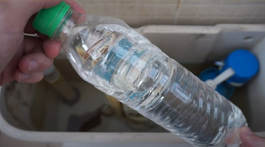Đặt chai nước vào bể chứa nước bồn cầu.