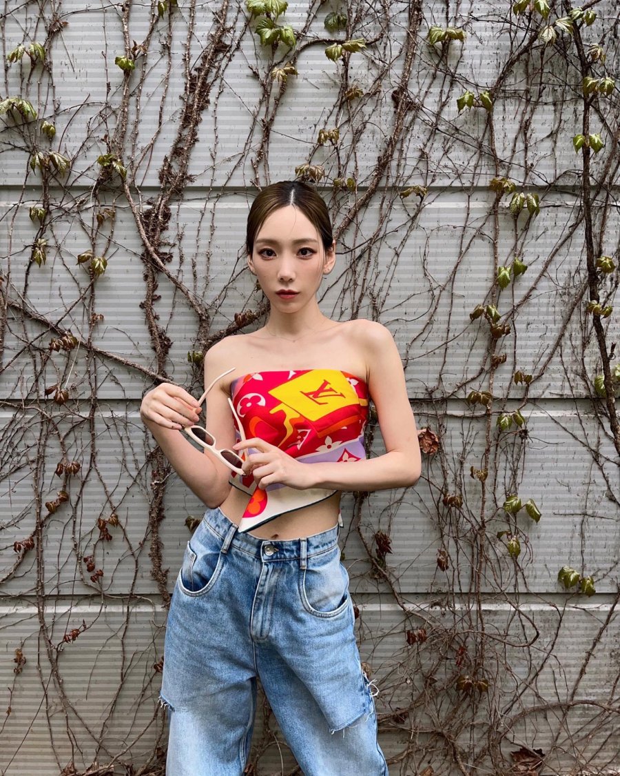 Taeyeon kết hợp quần jeans với áo tank top hoặc áo thun màu trung tính... hay đôi khi là áo họa tiết cho mới mẻ. 