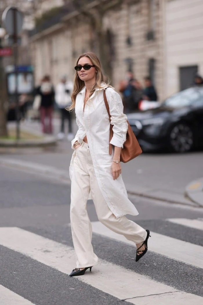 Phong cách đường phố với quần jeans trắng, váy sơ mi và giày sligback.