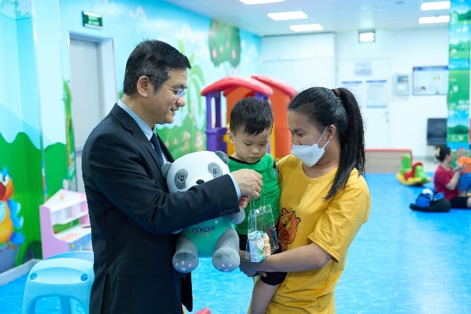 Ông Nguyễn Quang Trí – Giám đốc Điều hành Vinamilk, tặng quà cho các gia đình, các bé đến tiêm ngừa tại Trung tâm VNVC trong ngày kí kết hợp tác