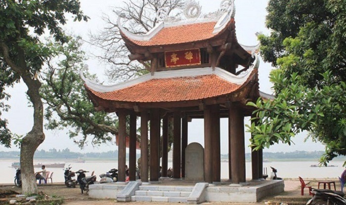 Đền Chử Đồng Tử nằm ngay bên bờ sông Hồng, nổi bật với lối vào rợp bóng mát từ hai hàng cây xanh