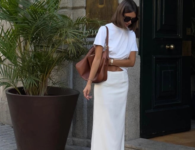 Áo thun trắng mix được cùng chân váy nữ tính. Quý cô người Pháp đã chọn túi xách màu nâu để đảm bảo có điểm nhấn hơn.     