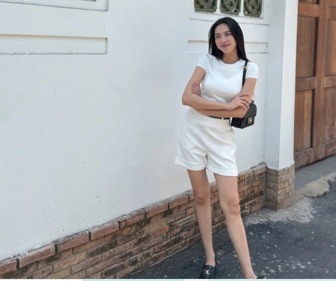 Bộ trang phục của Hoa hậu Thùy Tiên gồm áo thun và quần short xuyệt tông màu trắng này khi đi dạo phố hoặc du lịch.