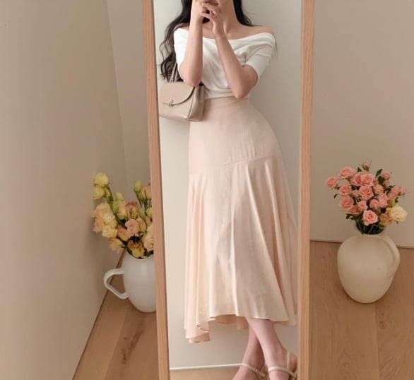 Áo trắng trễ vai và chân váy màu be thêm thao sơ vin và hoàn thiện outfit bằng một đôi sandal cao gót quai ngang là chuẩn bài.