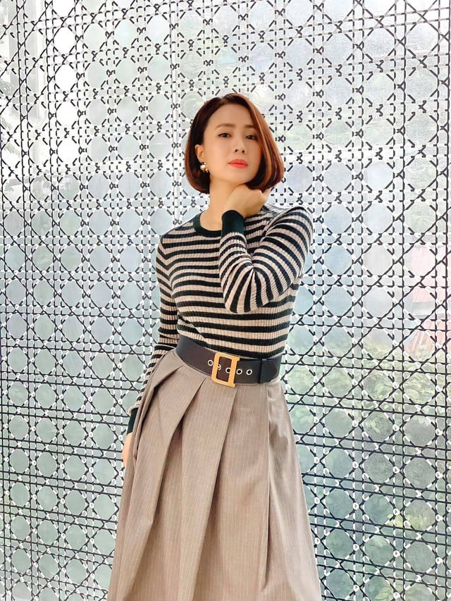 Nổi bật nhưng vẫn thanh lịch là ấn tượng về outfit gồm áo len kẻ ngang kết hợp với chân váy xếp ly.