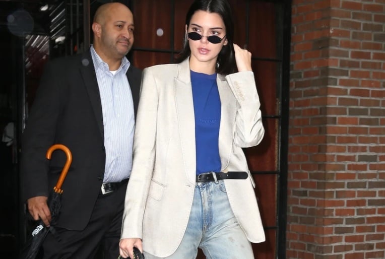 Tổng thể trang phục trở nên nổi bật hơn khi Kendall Jenner kết hợp blazer trắng với áo màu xanh đậm, quần jeans rách. 