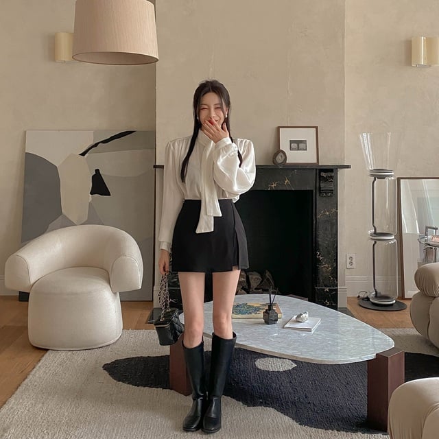 Áo blouse cổ nơ nên mix với chân váy ngắn và boots cao cổ. 