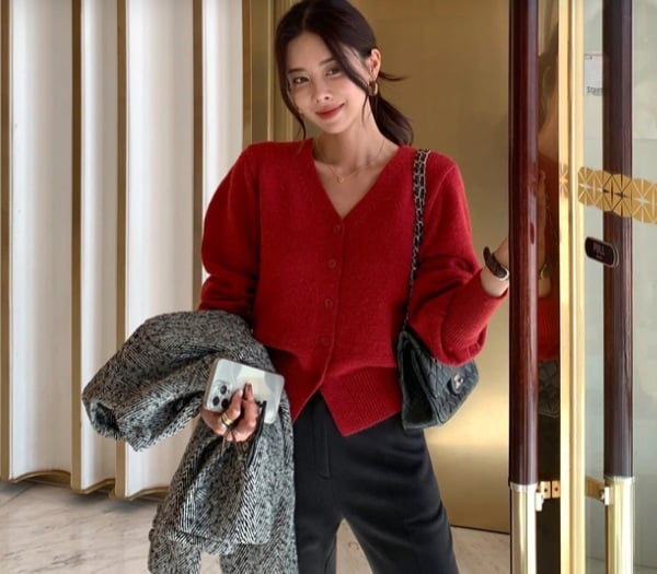 Trang phục gồm cardigan đỏ và quần đen mang lại sự đơn giản nhưng không kém phần thanh lịch.