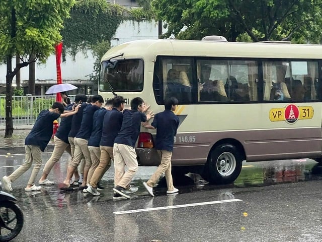 Nước ngập sâu khiến ô tô bị chết máy. Một nhóm học sinh phải xuống xe hỗ trợ tài xế đẩy xe trong sáng 25/8. (Ảnh: Lâm Black/OFFB)