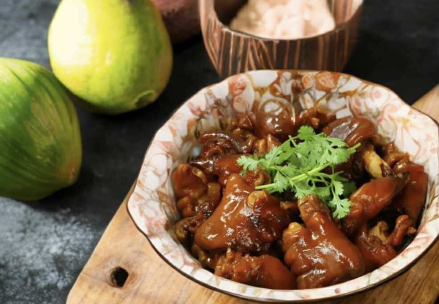 Món móng giò hầm tàu xì bày ra đĩa, trang trí thêm rau mùi, thơm ngon và hấp dẫn khó cưỡng.