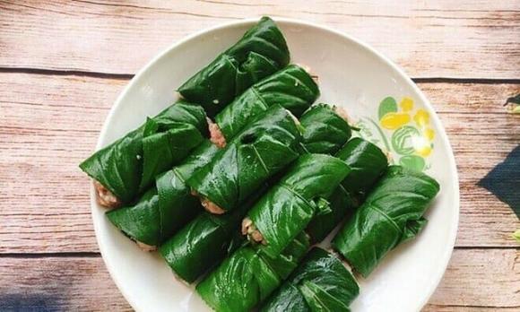Trải lá xương sông ra mặt phẳng thớt hay mâm cho sach, múc lượng nhân phù hợp vào rồi cuốn lại