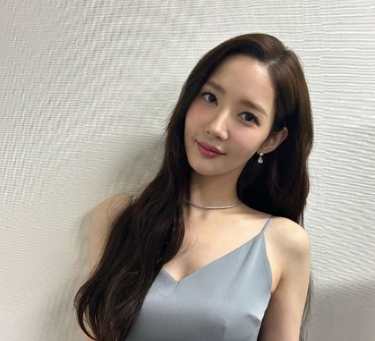 Park Min Young thường để tóc duỗi phồng kết hợp ngôi lệch 7/3, giúp gương mặt dài trở nên hài hòa hơn. 