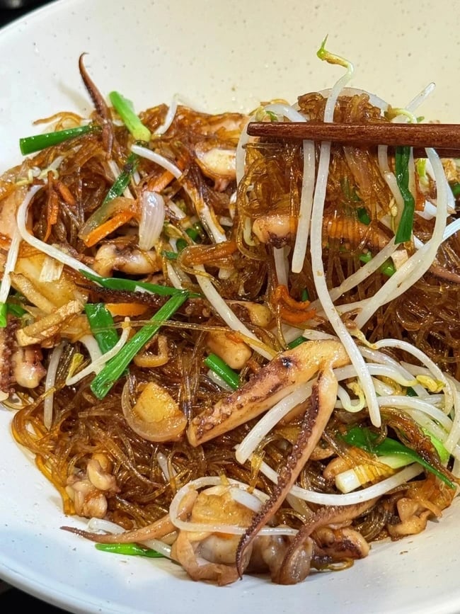Mực xào miến dai ngon, đậm vị với sợi miến thấm đều gia vị, ăn hoài không ngán.