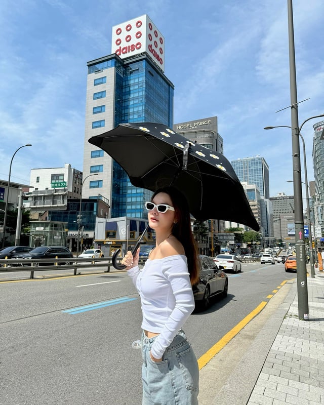 Chiếc áo trắng trễ vai giúp khoe khéo bờ vai mềm mại, trong khi quần jeans xanh lại mang đến chút bụi bặm, cá tính.