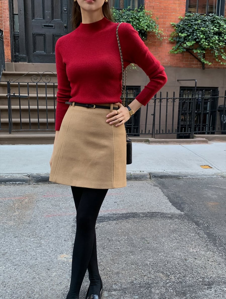 Áo len đỏ mỏng và chân váy be là sự kết hợp mang đến vẻ tươi tắn, tràn đầy sức sống, rất hợp không khí lễ hội. 