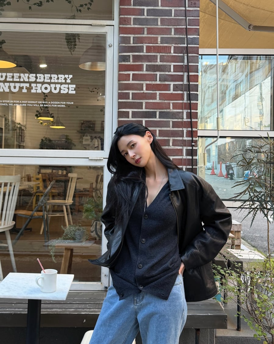 Sự kết hợp giữa áo cardigan và quần jeans xanh vốn quen thuộc, nhưng Kwon Nara làm mới bằng cách khoác thêm áo da bên ngoài.