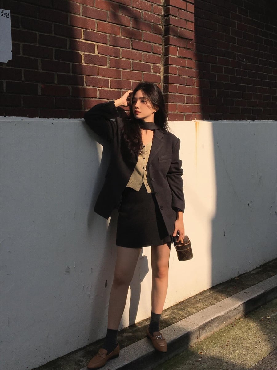 Với phong cách nữ tính hơn, có thể chọn váy đen dáng ngắn đi kèm giày mary jane hoặc sandals dây mảnh.   