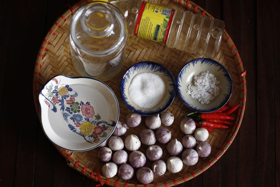 Tỏi bóc bỏ vỏ, rửa sạch bằng nước sôi để nguội. Tùy theo sở thích để nguyên tép tỏi ngâm hoặc cắt lát. Nếu để nguyên tép thì có vị giòn và giữ được nhiều tinh dầu hơn. 