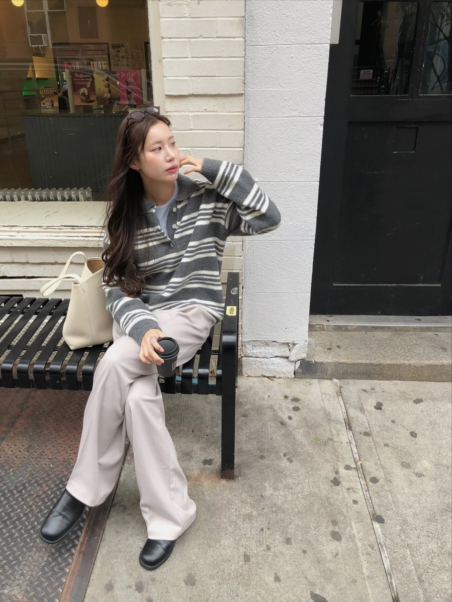 Những đường kẻ trên áo len đóng vai trò tạo điểm nhấn, trong khi quần ống suông giúp cân bằng tỷ lệ cơ thể, mang lại cảm giác gọn gàng hơn.