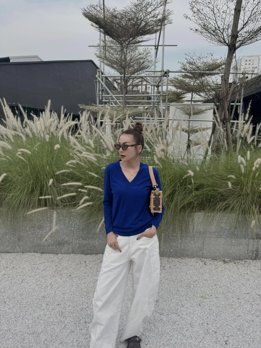 Cô thường chọn áo dài tay có màu đỏ, xanh cobalt hoặc các gam màu nổi khác nhưng thiết kế luôn tối giản, không nhiều chi tiết.