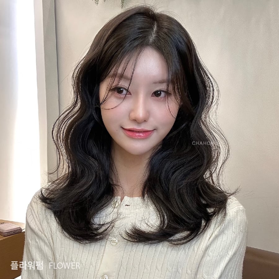 Kiểu tóc này giúp gương mặt trông mềm mại hơn, đặc biệt phù hợp với những khuôn mặt tròn hoặc có đường nét đầy đặn, mang lại vẻ ngoài nhẹ nhàng và hài hòa.