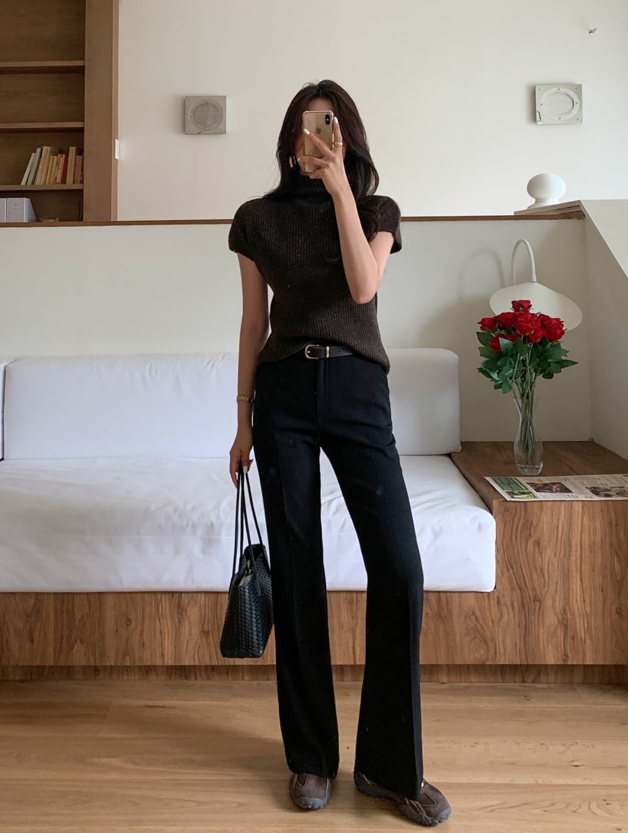 Áo len dáng ôm nhẹ giúp tôn đường nét cơ thể, trong khi quần đen giữ vai trò trung hòa, khiến tổng thể hài hòa và dễ ứng dụng hơn trong nhiều hoàn cảnh. 