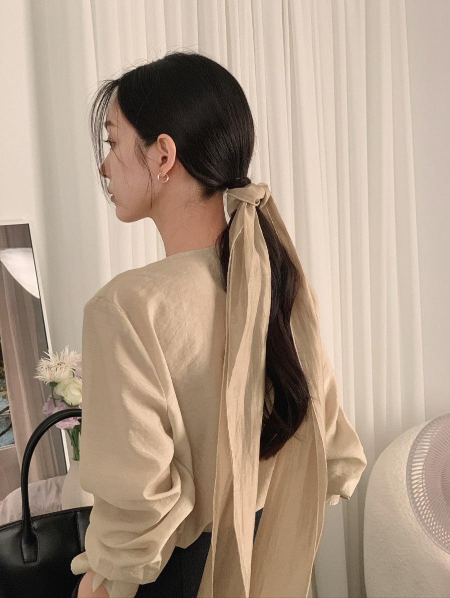 Khi chụp ảnh, tóc buộc thấp giúp gương mặt trông thon gọn hơn và tạo cảm giác mềm mại. 