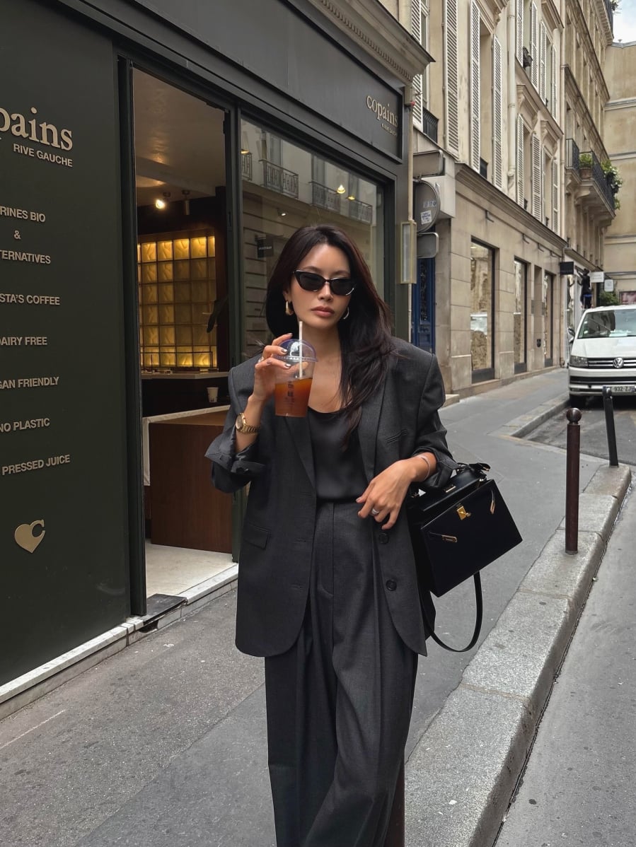 Phần vai được xử lý mềm, giảm bớt độ cứng của đệm vai, trong khi chiều dài áo thường phủ nhẹ qua hông để tạo cảm giác thanh thoát.