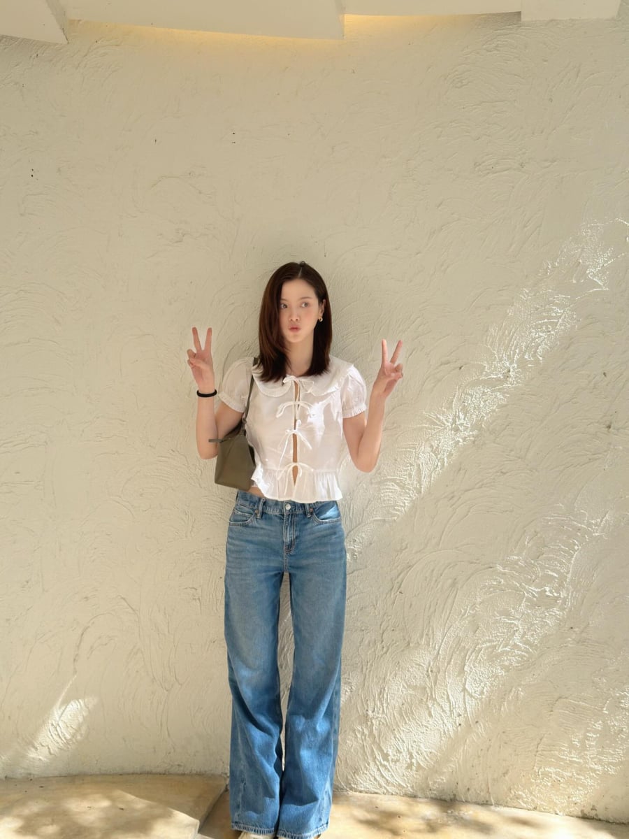 Một trong những công thức trang phục quen thuộc của Baifern là áo blouse trắng tay bồng kết hợp với quần jeans xanh. 