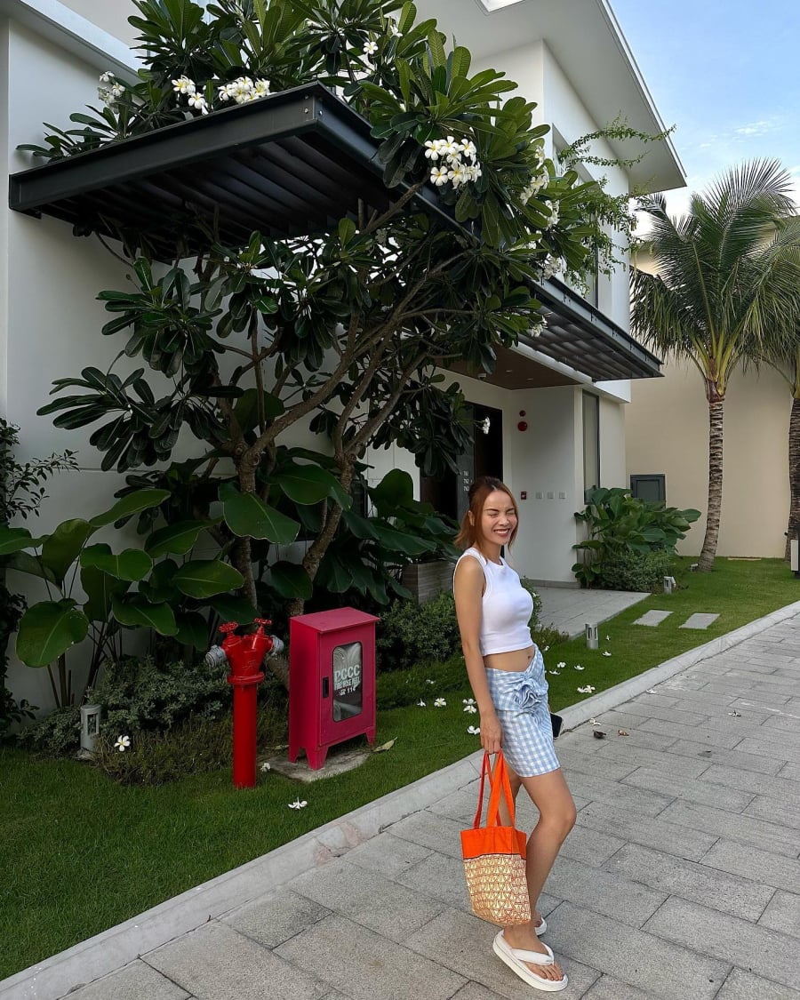 Chân váy ngắn họa tiết khi kết hợp với áo crop top trắng tạo nên bộ trang phục trẻ trung, năng động.