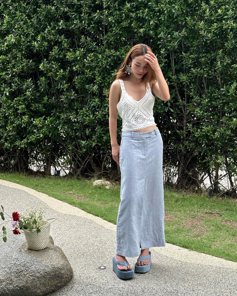 Sự kết hợp giữa áo hai dây và chân váy denim sáng màu mang đến cảm giác phóng khoáng, rất phù hợp với không khí du lịch. 