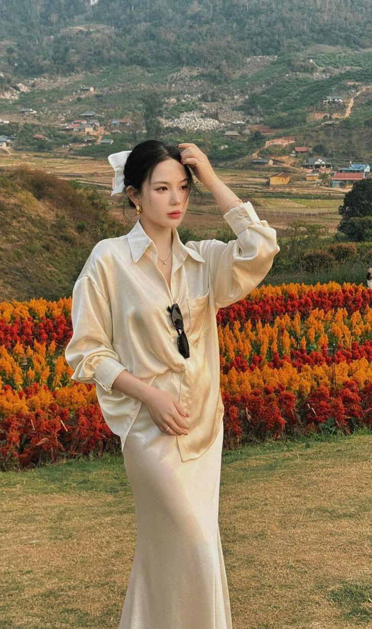 Sự đối lập giữa phom áo thoải mái và chất liệu váy mềm mại tạo nên tổng thể cân bằng, vừa hiện đại vừa tinh tế.