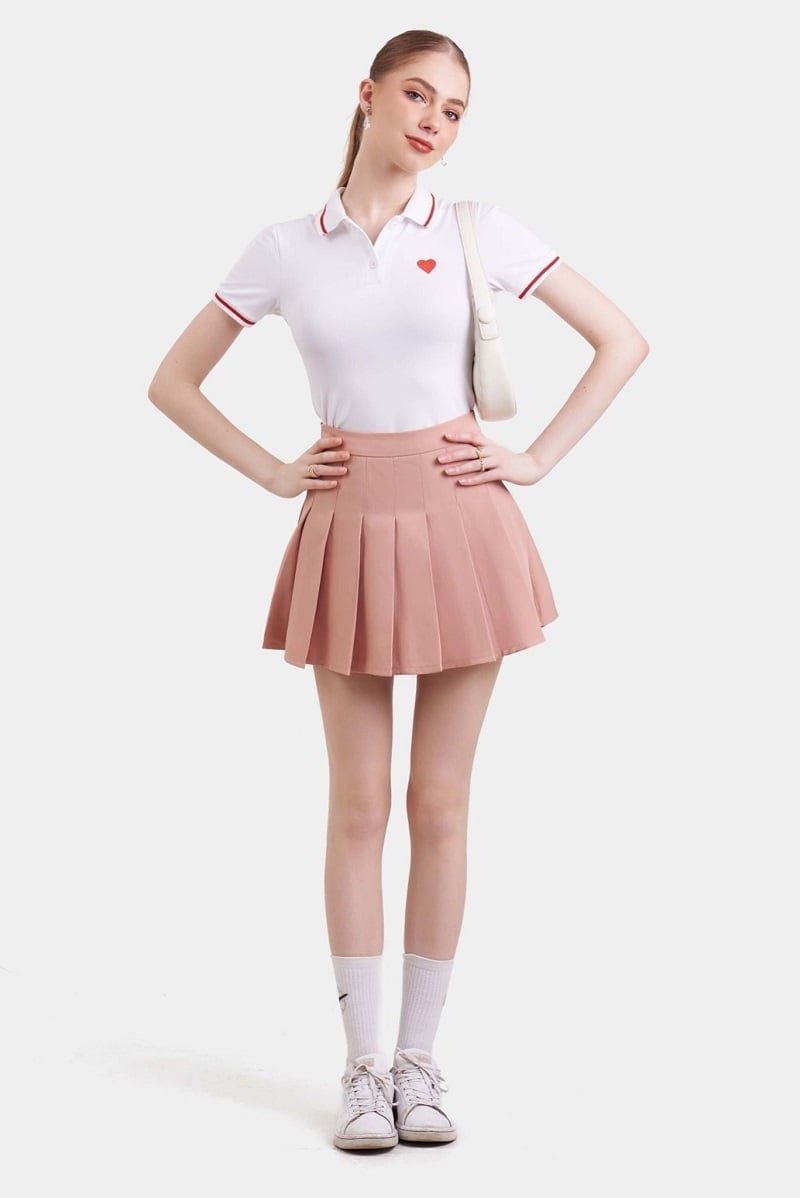 Sự đối lập giữa vẻ khỏe khoắn của áo đấu và nét nữ tính của chân váy tạo nên tổng thể hài hòa, vừa năng động vừa cuốn hút.
