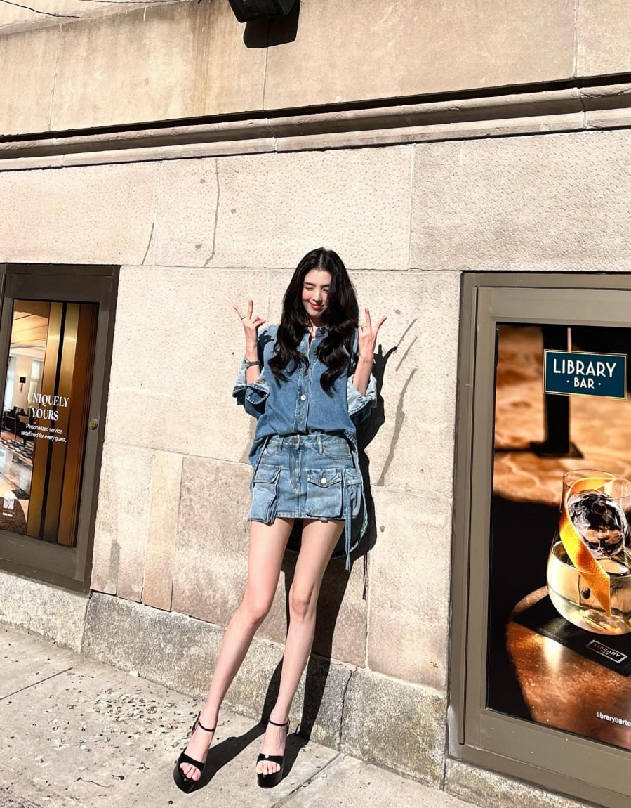 Cô lựa chọn áo sơ mi denim dáng rộng kết hợp chân váy mini cargo cùng chất liệu, tạo nên tổng thể trẻ trung và cá tính.