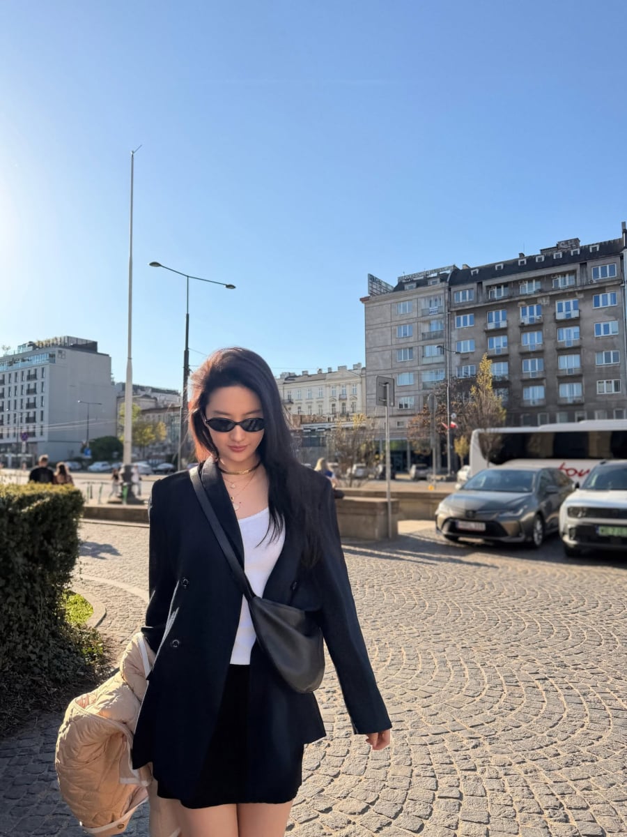Một chiếc áo thun trắng đơn giản được kết hợp cùng blazer màu đen và chân váy đồng điệu mang đến tổng thể hài hòa, hiện đại.