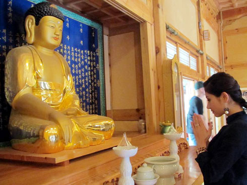 Hương Giang thành kính cầu nguyện trước bàn thờ Phật Tổ.