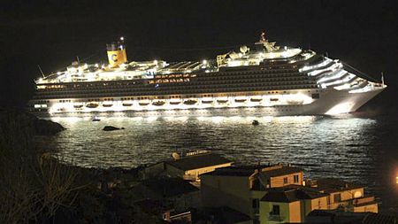 Tàu Costa Concordia rực sáng trên biển trong khi bị nghiêng hẳn sang một bên. Ảnh: Daily Mail
