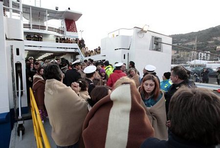 Các hành khách của Costa Concordia tên một chiếc phà tại Porto Santo Stefano, Italia. Ảnh: AFP